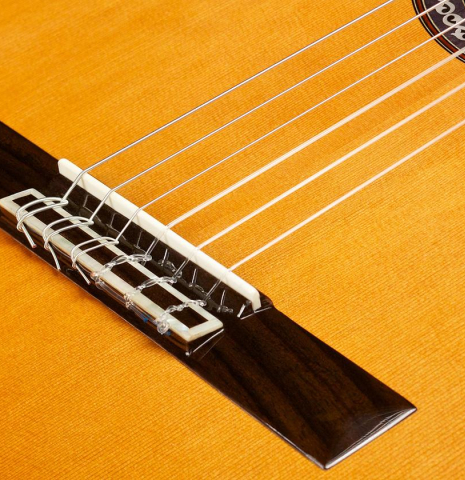 The bridge, tie-block and saddle of a Cordoba "C9" classical guitar made of cedar and mahogany