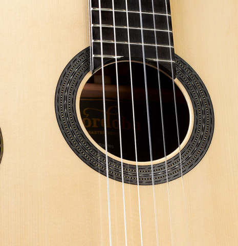 The top and rosette of a Cordoba Guitars Master Series "Torres" classical guitar made of spruce and Indian rosewood