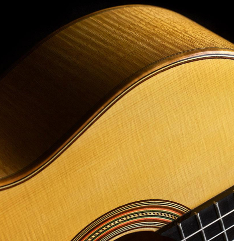The soundboard, binding and side of a 2018 Paolo Coriani 1907 Enrique Garcia copy classical guitar made of spruce and maple