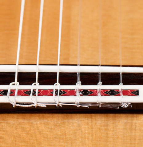The bridge and nylon strings of a 2022 Cordoba Luthier Select Series &quot;Friederich&quot; made of cedar and Indian rosewood