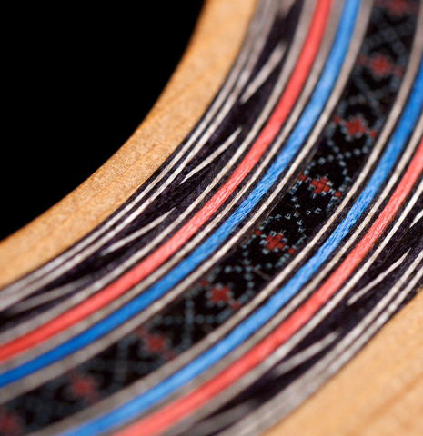 A close-up of the rosette of a 2022 Luis Fernandez de Cordoba "Tricolor" made of cedar and wenge