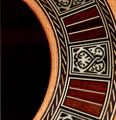 This is the rosette of a Cordoba "Double Top 25th Anniversary" classical guitar built in 2022. It features ornate Anniversary-inspired engraved pearl and rosewood rosette.