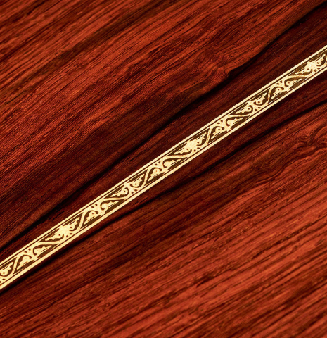 A close-up of the back of a 2022 Cordoba &quot;20th Anniversary&quot; classical guitar made of spruce and African rosewood