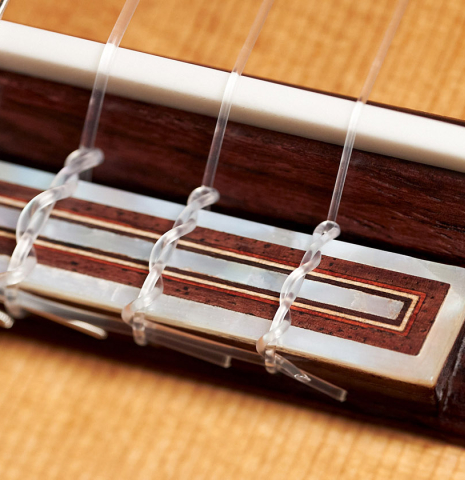 The bridge, tie-block, saddle and nylon strings of a new Cordoba Luthier Select Series &quot;Santos Hernandez&quot; made of spruce and maple