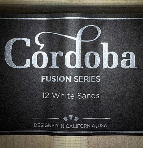 The label of a Cordoba Guitars "Fusion 12 White Sands" classical crossover guitar made of spruce and maple