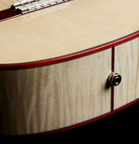 The endping 1/4 inch jack of a Cordoba Guitars "Fusion 12 White Sands" classical crossover guitar made of spruce and maple