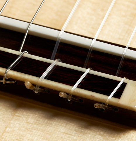 The bridge, tie-block and saddle of a 2024 Andy Culpepper classical guitar made of spruce and CSA rosewood