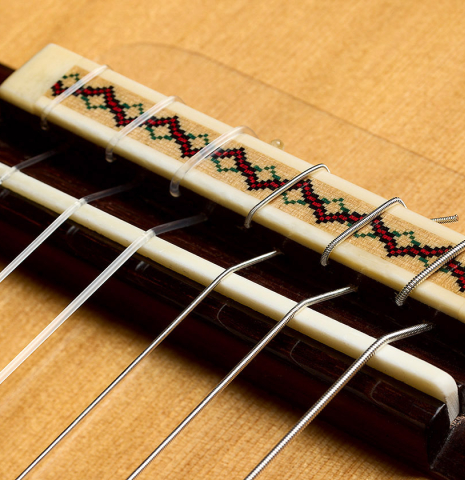 The bridge, tie-block and saddle of a 2025 Andy Culpepper classical guitar made of cedar and Honduran rosewood