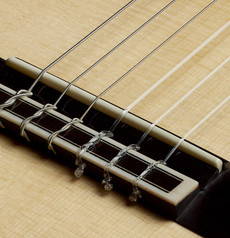 The bridge, tie-block and saddle of a 2020 Yulong Guo "Granada" classical guitar made of spruce and CSA rosewood