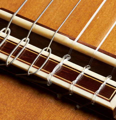 The bridge, tie-block and saddle of a 1998 David Daily classical guitar made of cedar and Indian rosewood