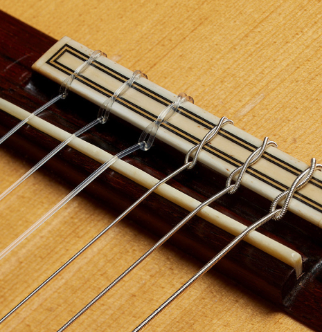 The bridge, tie-block and saddle of a 1987 David Daily classical guitar made of spruce and CSA rosewood