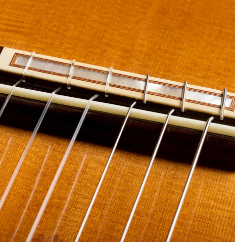The bridge, tie-block and saddle of a 1999 Matthias Dammann double-top classical guitar made of cedar and CSA rosewood