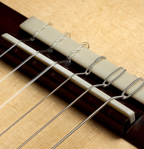 The bridge, tie-block and saddle of a 2025 Thomas Dauge classical guitar made of spruce and African rosewood