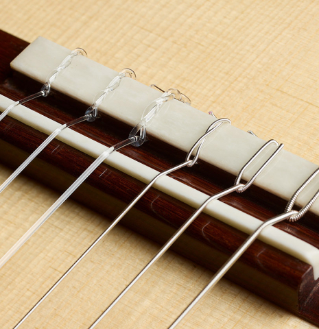 The bridge, tie-block and saddle of a 2026 Thomas Dauge classical guitar made of spruce and African rosewood