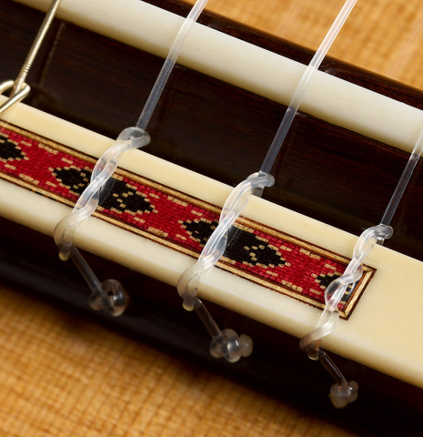The bridge, tie-block and saddle of a 2019 Thomas Dauge "d'après Daniel Friederich" classical guitar made of cedar and Indian rosewood