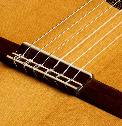 The bridge, tie-block and saddle of a 1993 Christopher Dean classical guitar made of spruce and Indian rosewood
