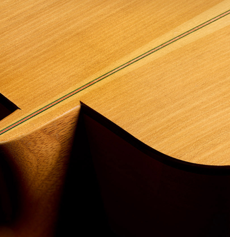 The heel, back binding and purfling of a 2012 Robert Desmond "cutaway w/electronics" classical guitar made of spruce and cypress