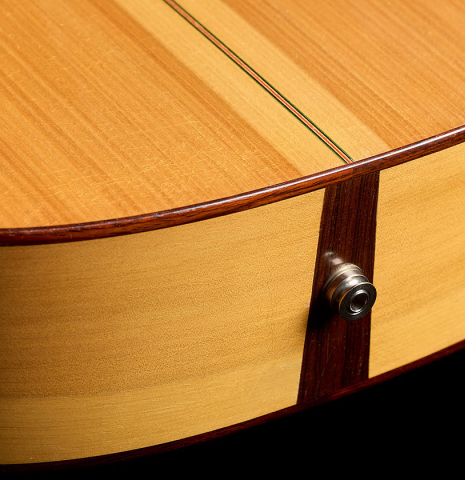 The back, sides and endpin of a 2012 Robert Desmond "cutaway w/electronics" classical guitar made of spruce and cypress