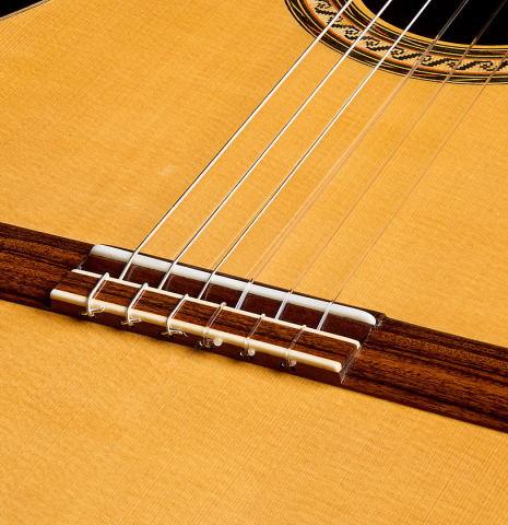 The soundboard and bridge of a 2015 Ethan Deutsch w/pegs flamenco negra guitar made of spruce and CSA rosewood