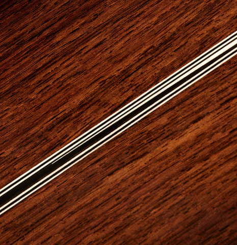 The back center seam of a 2024 Marc Dickinson “Cosmic” classical guitar made of cedar and Indian rosewood