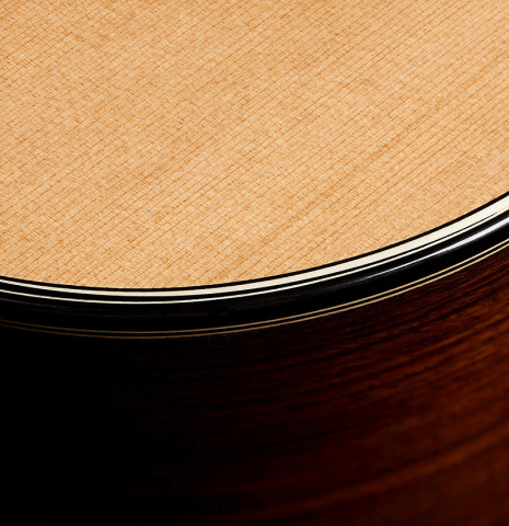 The top binding and purfling of a 2024 Marc Dickinson “Cosmic” classical guitar made of cedar and Indian rosewood