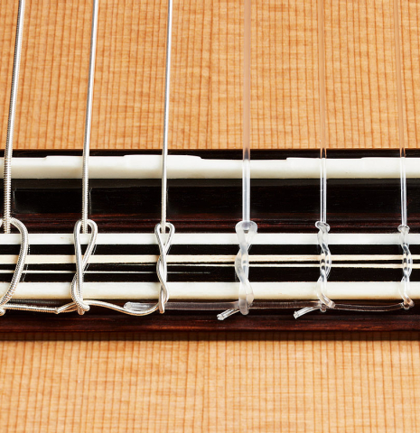 The bridge, tie-block and saddle of a 2024 Marc Dickinson “Cosmic” classical guitar made of cedar and Indian rosewood