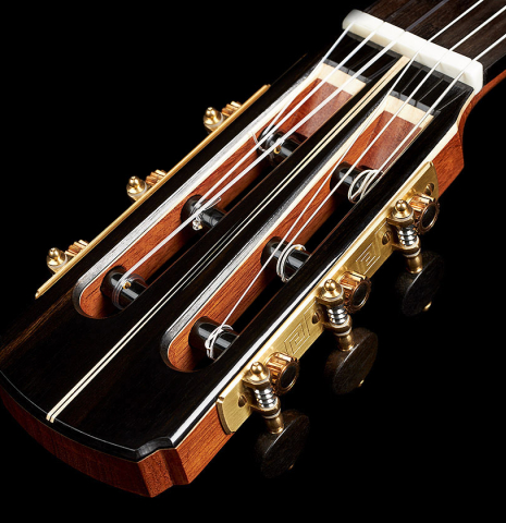 The headstock, veneer inlay and tuning machines of a 2023 Marc Dickinson "Cosmic" classical guitar made of spruce and Indian rosewood