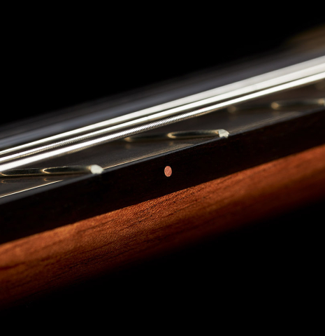 The side of the fingerboard of a 2023 Marc Dickinson "Cosmic" classical guitar made of spruce and Indian rosewood