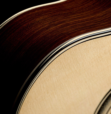 The top binding and purfling of a 2025 Marc Dickinson "Cosmic" classical guitar made of spruce and Indian rosewood