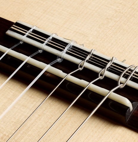 The bridge, tie-block and saddle of a 2026 Marc Dickinson "Cosmic" classical guitar made of spruce and African blackwood