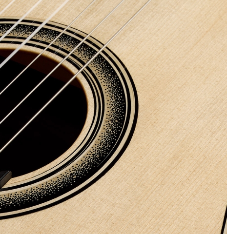 The soundboard and rosette of a 2026 Marc Dickinson "Cosmic" classical guitar made of spruce and African blackwood