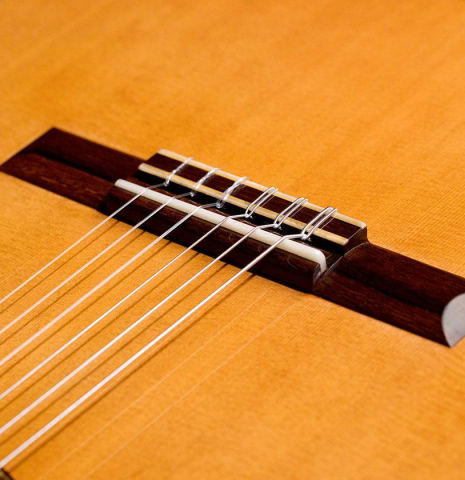 The bridge of a 2020 Vladimir Druzhinin classical guitar made of cedar and African rosewood. The bridge of a 2020 Vladimir Druzhinin classical guitar made of cedar and African rosewood.