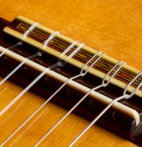 The bridge, tie-block and saddle of a 2026 Vladimir Druzhinin "Special" classical guitar made of spruce and African rosewood