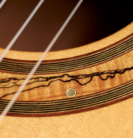 The flamed maple rosette of a 1994 Jeffrey Elliott classical guitar made with spruce and Indian rosewood.