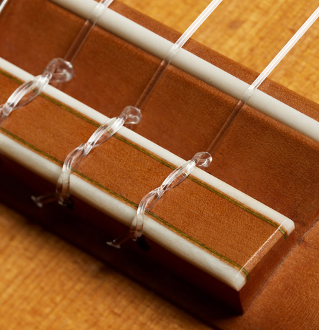 The bridge, tie-block and saddle of a 1981 Jeffrey Elliott classical guitar made of spruce and CSA rosewood