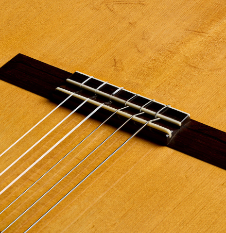 The bearclaw soundboard, bridge, tie-block and saddle of a 1990 Jeffrey Elliott classical guitar made of spruce and African blackwood