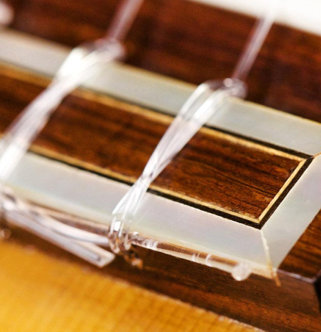 The bridge, tie-block and saddle of a 1932 Domingo Esteso classical guitar made of spruce and CSA rosewood