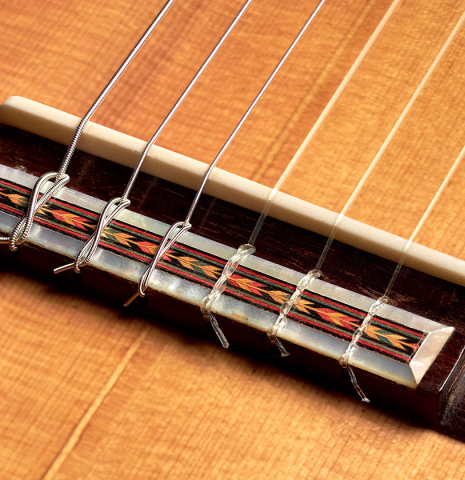 The bridge and saddle of a 1933 Domingo Esteso classical guitar made with spruce and CSA rosewood