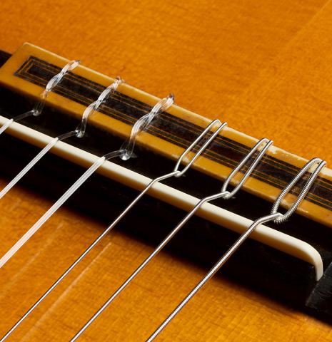 The bridge, tie-block and saddle of a 1966 Arcangel Fernandez classical guitar made of spruce and CSA rosewood