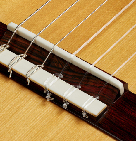 The bridge, tie-block and saddle of a 2025 Dominique Field classical guitar made of spruce and CSA rosewood