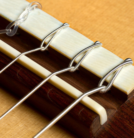 The bridge, tie-block and saddle of a 2011 Dominique Field classical guitar made of spruce and CSA rosewood