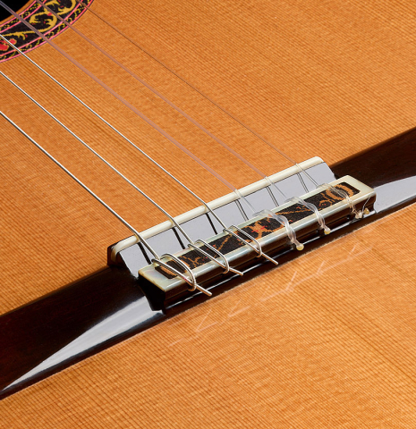 The bridge, tie-block and saddle of a 2008 Paul Fischer "Premier" classical guitar made of cedar and CSA rosewood