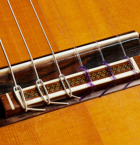 The bridge, tie-block and saddle of a 1960 Ignacio Fleta classical guitar made of spruce and CSA rosewood