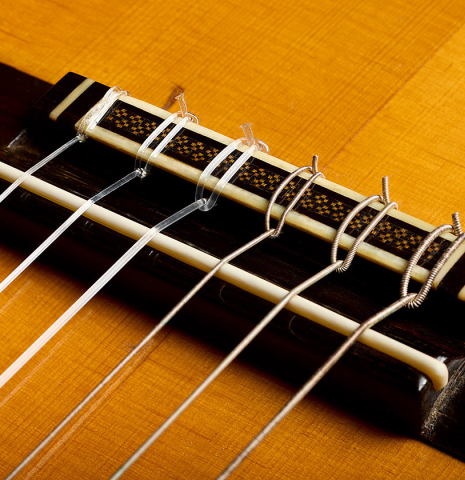 The bridge, tie-block and saddle of a 1960 Ignacio Fleta classical guitar made of spruce and Indian rosewood