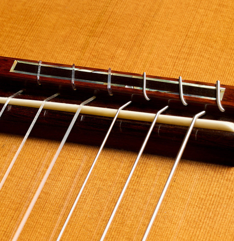 The bridge, tie-block and saddle of a 2008 Thomas Fredholm classical guitar (ex John Dearman) made of spruce, CSA and Indian rosewood