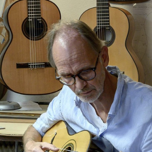 Thomas Fredholm playing a guitar in his workshop in Göteborg, Sweden