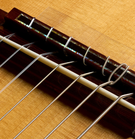The bridge, tie-block and saddle of a 2011 Thomas Fredholm "7-string" classical guitar (ex John Dearman) made of spruce and Indian rosewood
