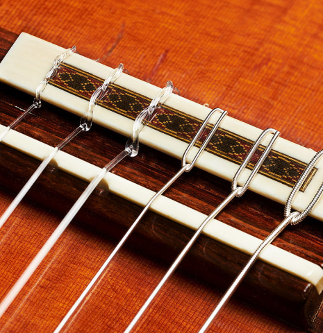 The bridge, tie-block and saddle of a 1984 Daniel Friederich classical guitar made of cedar and Indian rosewood.