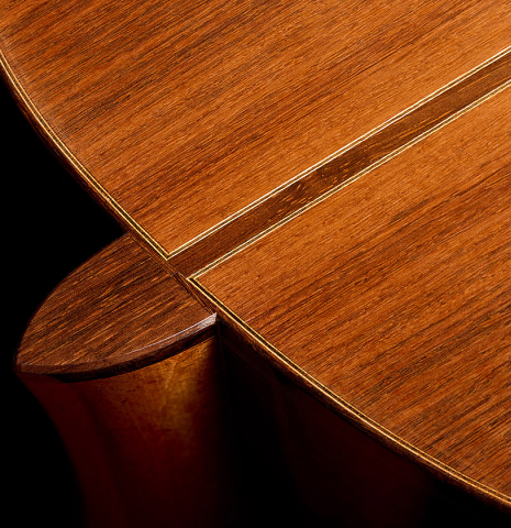 The heel, back binding and purfling of a 1975 Daniel Friederich classical guitar made of cedar and Indian rosewood