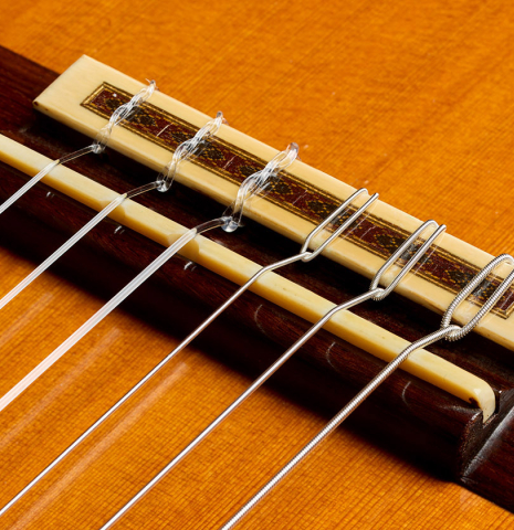 The bridge, tie-block and saddle of a 1975 Daniel Friederich classical guitar made of cedar and Indian rosewood